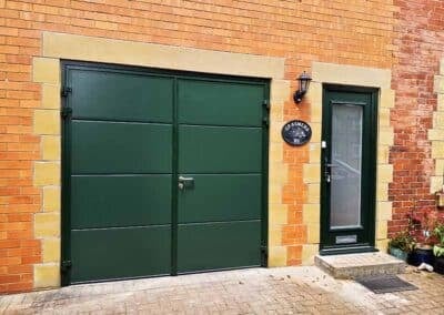 Side hinged garage door in green with matching front door